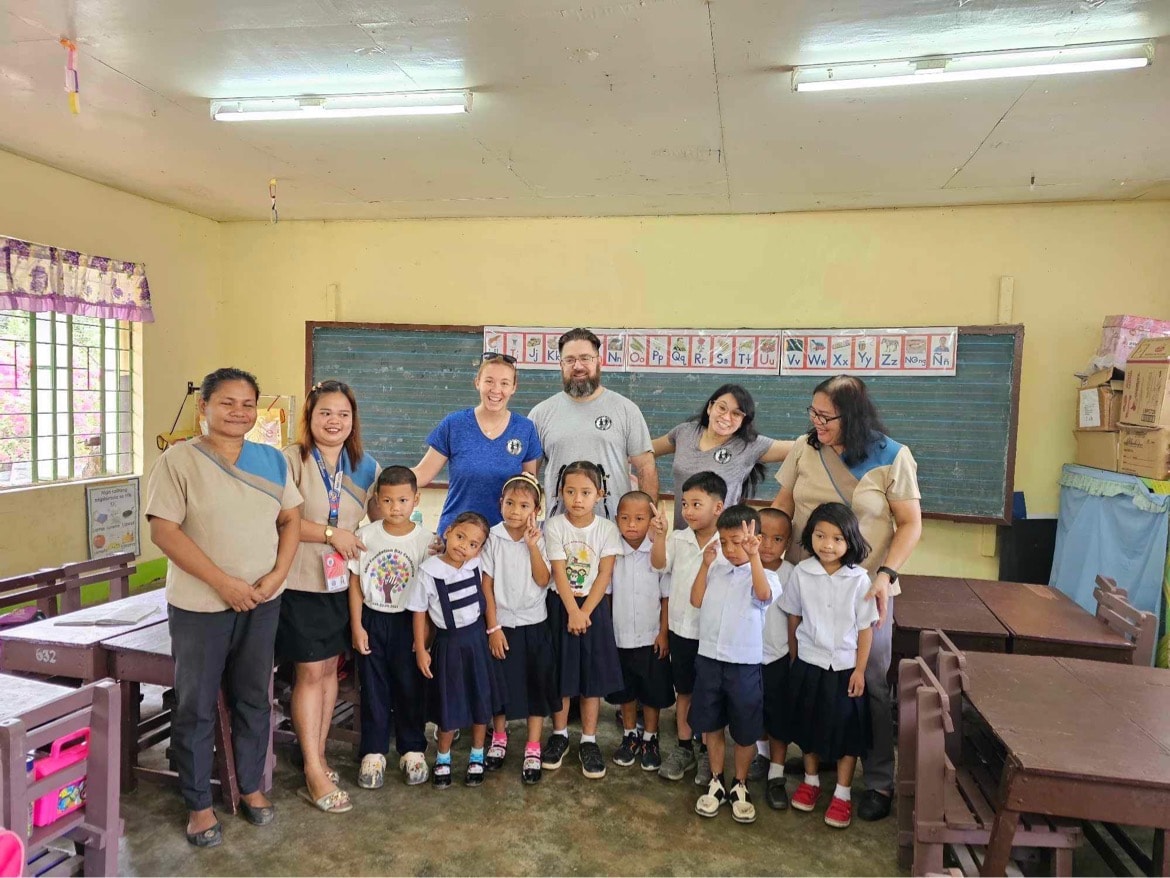 Dan Arcand with students and teachers in a classroom in the Philippines